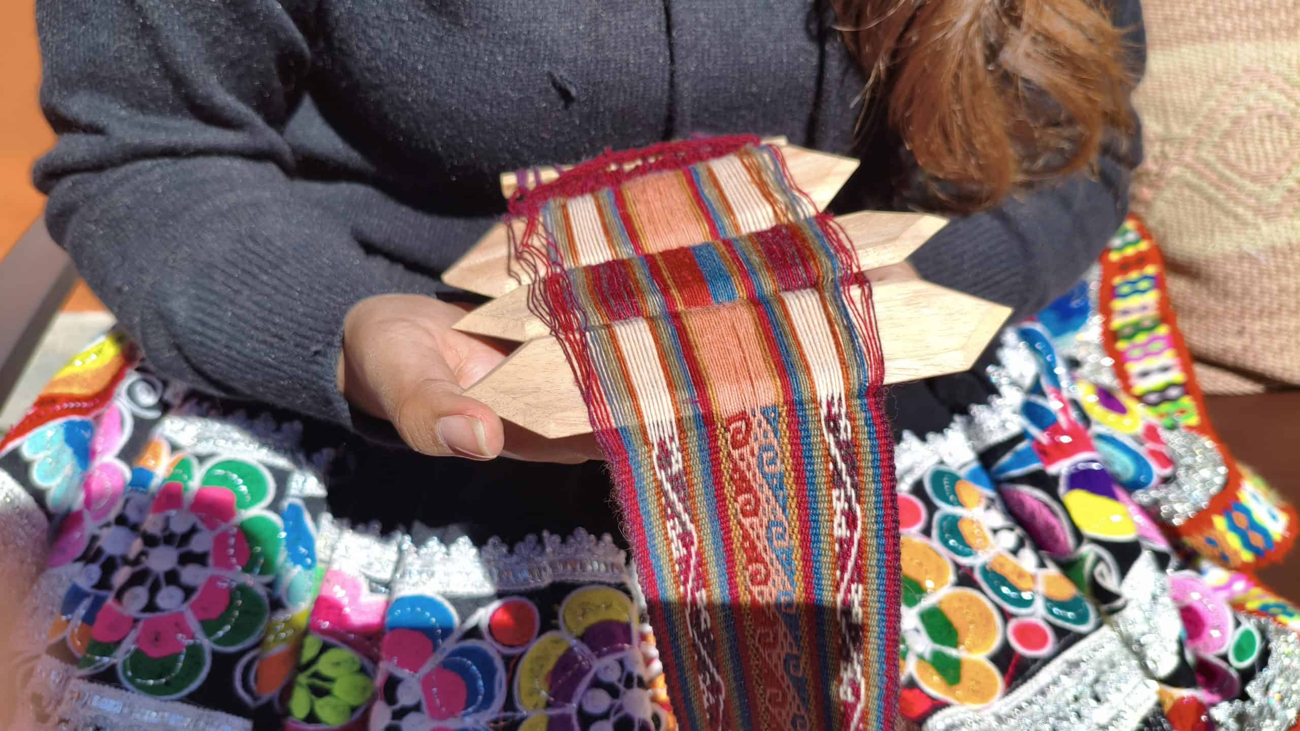 Close-up of colorful Peruvian textile craft with wooden frame.